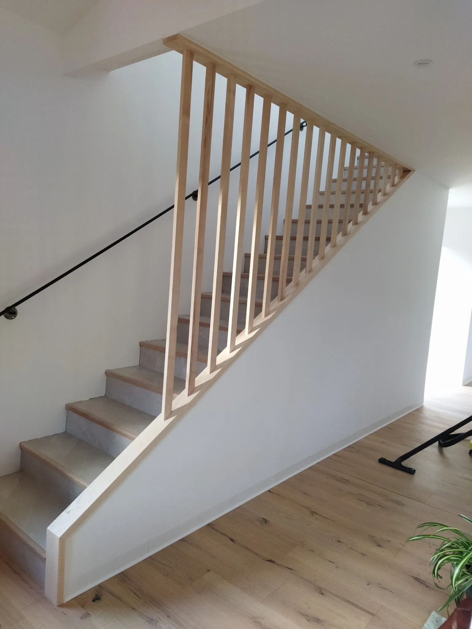 Escalier en bois moderne avec des garde-corps en bois clair, apportant élégance et fonctionnalité à l'aménagement intérieur.