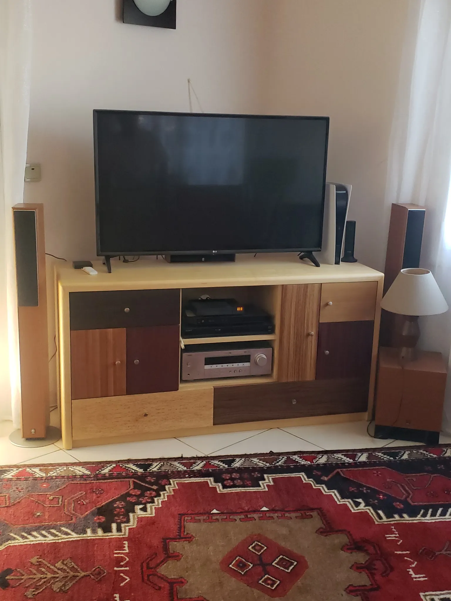 Meuble TV en bois au design personnalisé avec diverses nuances et compartiments, illustrant un travail d'ébénisterie unique.